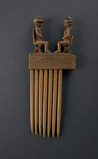 (UEM27071)&amp;#160;Carved wooden comb decorated with two human-like male figures wearing round hats, sitting on chairs facing each other. Chokwe combs, decorated with geometrical designs typical of their art, were made for hair styling, often in conjunction with castor oil and red mud. The artistic designs symbolised social rank. The decorative carving of male figures facing each other could represent a chief’s authority and spiritual powers. The two male figures seated on a European-style chair are wearing European-style round hats. Among the Chokwe, hats could be infused with a magical substance. The design of the chairs and hats suggests how new ideas and commodities entered society through contact with Europeans from around the 16th Century. If so, the carvings would signify a changing world and the incorporation and adaptation of new influences in Chokwe society. The European-style chairs and hats may represent figures of authority, such as chiefs or ancestors, interacting with Europeans to connect the Chokwe allegiance to chiefs and ancestors within a changing socio-political environment. Material: Wood Region: Kasai, Chokwe Height: 20 cm. Arrival: Donated to the Museum by Dr Inge Heberg, 1920.