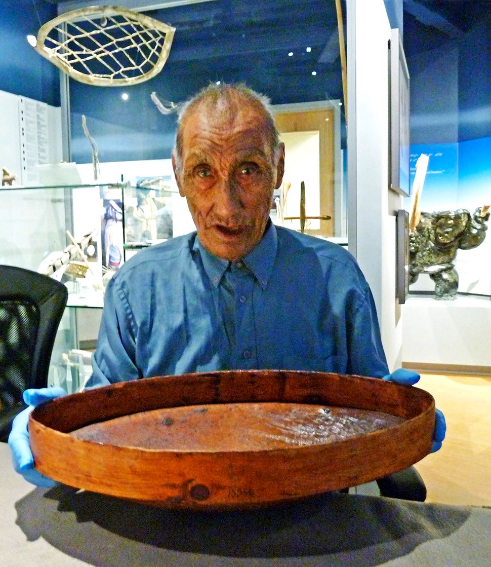 Jonathan Hiqiniq with the iliviaq from the Gjoa Haven/ Amundsen collection at the Nattilik Heritage Centre in Gjoa Haven, October 2014