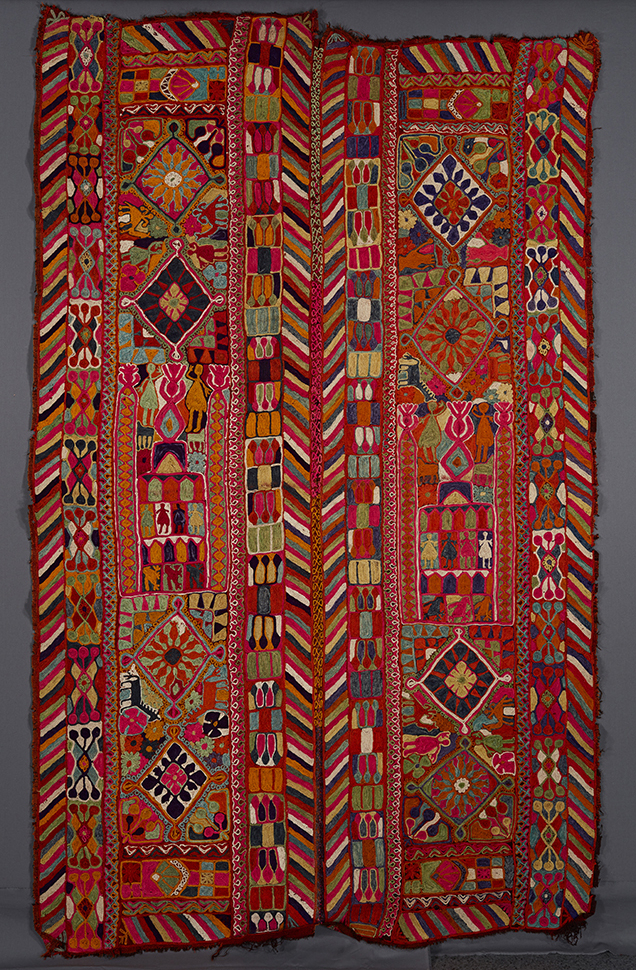 UEM49192. Double bordered on the vertical sides of the two panels. Characteristic multi-colored diagonal lines pattern on the inner and outer edges of both panels. Each panel is divided into three sections. Outer sections of each panel: two diamonds surrounded by flowers, animals, and human figures. The central section of each panel: a possible architectural element with birds animals and human figures. 