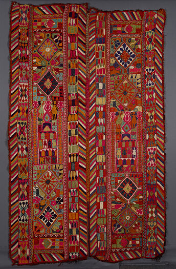 UEM49192. Double bordered on the vertical sides of the two panels. Characteristic multi-colored diagonal lines pattern on the inner and outer edges of both panels. Each panel is divided into three sections. Outer sections of each panel: two diamonds surrounded by flowers, animals, and human figures. The central section of each panel: a possible architectural element with birds animals and human figures. 