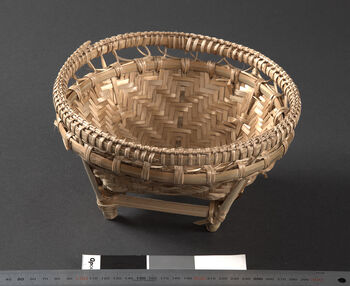 (UEM46918) A small basket for storing food items. Produced for sale and purchased at the market. The neighboring Khasi people did not have a strong weaving tradition themselves, but goods were exchanged at the markets. Woven (braided). Material: Bamboo and rattan. Khasi/Meghalaya district.