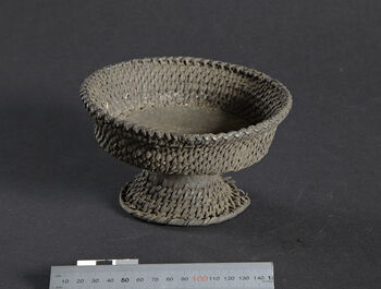 (UEM46924) Plate on a stem. Rattan binding, with a wooden base plate. It has been used for storing and serving betel leaves and areca nuts, which are commonly chewed and offered to all guests, both upon arrival and after meals. It is called k o-ve’ thok or k ovithok , with slight variations in spelling. West Karbi Anglong/Hamren district.