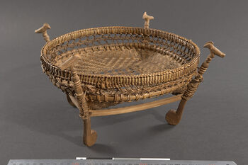 (UEM46928) Tray with wood carving of a bird/bone. Used for serving betel nuts and leaves, see also UEM46924 . It was Menon Ronghang from Bhaitalangso, the village of Umruh, who brought this in 1994. He did not know who made it or when. Materials: Rattan binding and bamboo weaving . Karbi Anglong/Bhaitalangso districts.