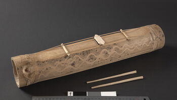 (UEM46958) Chengkumbang with mallet or striker. A player strikes the strings with two small bamboo sticks. Each chengkumbang produces a slightly different tone, and one listens to find which ones can play together.