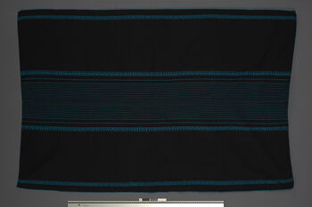 (UEM46847) Pini,  locally called ‘Thailand’. Woven using a loin loom, warp faced weave with pick-up pattern edging. Woven in two lengths and sewn together in the middle. Used by women for everyday use, parties and rituals. It is fastened with a wamkok belt that is tied around the waist. Material: Acryl.
