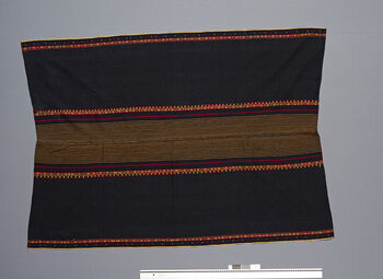 (UEM46848) Woven by Serdihun Weaving co-op, a local association of women. This color combination was popular from 1992 to 1994. Woven using a loin loom, warp faced weave with pick-up pattern edging. Woven in two lengths and sewn together in the middle. Used by women for everyday use, parties and rituals. It is fastened with a wamkok belt that is tied around the waist. Material: Acrylic, locally called ‘Thailand’. Hidipi, Karbi Anglong.