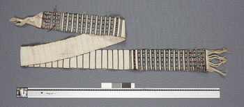 (UEM46849) A wamkok is tied around the waist over a pini to keep it in place. Wamkoks are woven using a loin loom. It is common for two to be woven at the same time. Each belt is then folded lengthwise and the edges are sewn together. This wamkok is not fully assembled. Pattern name: Dolong archak . Dolong means bridge, archak means column, or pillar. Material: Cotton.