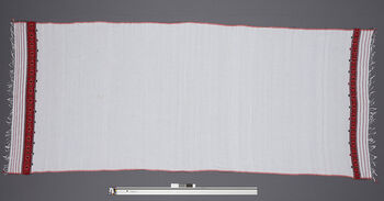 (UEM46869) Floor loom, plain weave, pick-up patterns. Used by men and boys on the lower body together with choy during feasts and rituals. Material: White cotton and borders in acryl.