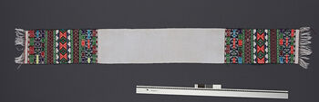 (UEM46877) Loin loom, plain weave. Pick-up patterns. Used by unmarried men. Patterns and colours on pohos have local variations. Material: white cotton, motifs in acryl. District: Hamren.