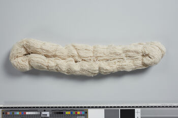(UEM46878) Two home-spun bundles ( honki/eri and tussar ). The bundle of tussar is spun on semi-industrial equipment. Eri ( honki ) is homespun.  Pekoks in thin silk t ussar or other varieties of silk are sometimes used in the Karbi community. These are often woven in the Assamese community in Sualkuchi (see UEM46911) with motifs and patterns from Karbi Anglong and sold on the local market. Having a pekok in silk indicates status.