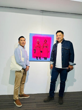Artist N. Otgonbat and Lobsan's great-grand-son, Mongolian pop star T. Bat-Orgil, posing in front of the image that would be used as the 'Enchanting Urga' exhibition poster. The girl right of the image is Bat-Orgil's grandmother, photographed by Mamen in 1913.