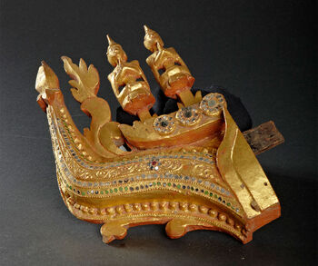 (UEM42093) Description: The altar is made of wood with carved ornaments, covered with gold and decorated with precious stones. 4 loose parts cannot be fitted in. Classification: Sacred objects and places / Wood craftsmanship. Material: Gold (metal), wood, mirror glass (glass), stone. Collection history: Has stood in a pagoda in Akyab. "In the main catalog at No. 40717, there is a note with information about how this altar and several other Buddhist objects came into the possession of the donor (…)" (Translation from the original Norwegian catalog card). Dimensions: Length 26 cm. Width: 5 cm. Height: 16.5 cm. Donor: Mrs. Gunhild Løchen Christensen. The lady's brother, consul G. Løchen, collected the items. Received by the museum in 1958.