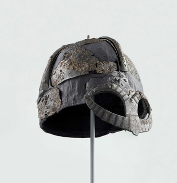 The notion that all Vikings, women and men, young and old, wore helmets with horns is alive and well in popular culture. Nevertheless, that was not the case. Only two relatively complete helmets from the Viking Age have been discovered and they have no sign of ever having had horns. The Viking helmet from Gjermundbu has protection for the eyes and nose, at the bottom of the helmet there are marks after attachment for metal plates or chain mail that have hung as protection for the neck. But zero horns. There is evidence that a helmet or similar headgear with a kind of horn has been used at Viking ceremonies. The Oseberg textiles are decorated with figures wearing horned helmets. On the other hand, the Vikings did not wear horns on helmets used in combat, which would have reduced mobility and increased instability. The Gjermundbu helmet is on exhibition in VÍKINGR.&amp;#160;C27317.