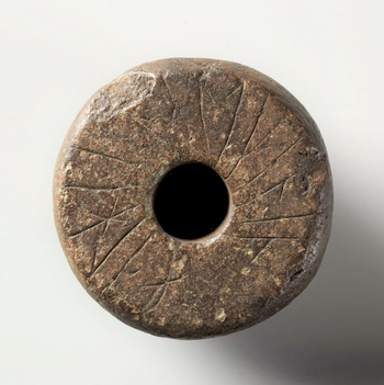 "Halha · a snalt þenan" says the inscription on this spindle-whorl of stone. In classical Old Norse this sounds Helga á snáld þenna, meaning “Helga owns this spindle-whorl”. The word snáldr refers to the spindle-whorl, still known in some Norwegian dialects as “snåld”. The inscription is from the late Viking Age or early Middle Ages. The object was found in the 1950s by teacher Jon T. Uppstad under the old smokehouse at Uppstad farm in Valle, Norway. Spindle-whorls were a common tool in the spinning of thread. Several runic inscriptions are known on spindle-whorls from Scandinavia and elsewhere. In this manner people could mark the practical tools in their everyday life. Runic signum: N 582. C28808.