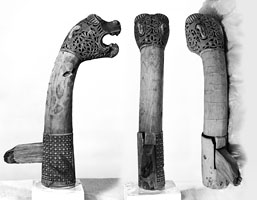 Three black and white photos of a snake carved from wood, taken from three different angles.