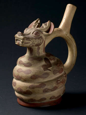 (UEM9968) Bottle in form of a mythical being is composed of a snake in low relief coiled around the chamber with a modeled head of a deer, with ears and spots of a jaguar. Mold made. Polychrome painting brown and white (spout). Moche, 100–800, Peru.
