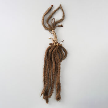 (UEM2446) A coil of braid attached to a wood cylinder, 112 cm. long. The original catalogue text from 1871 describe the object as ‘A long braid of human hair attached to a cylinder of wood’. Parts of the hair is braided into long braid while some is braided to a collar. Thin cords are braided together with the hair at times decorated with red feathers. Identical objects are not known from Rapa Nui and its use and meaning is unknown. The only known object described from Rapa Nui is a 16-17 meter long cord of braided human hair coiled around a rongorongo tablet (Echancrée/Ka Ihi Uiga) when donated to the French missionary Mgr. Jaussen in 1869 that led to the Rapa Nui hieroglyph sign system being known to Europeans. Peter Arup did not bring a rongorongo table back from Rapa Nui after his visit in 1869. According to Yngvar Nielsen, who categorized Arup’s donation from Rapa Nui, Arup supposedly collected such tablet yet gave it to the French missionaries who had showed their interest.