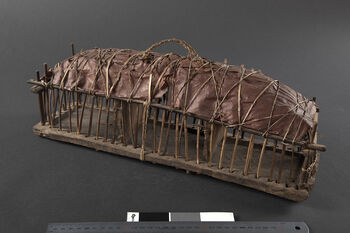 (UEM20865) Rev. Bodding’s notes: 'A&amp;#160;kind of cage with lattice of wood, wooden floor, 2 loose walls made of wood and an arched ceiling, covered with large leaves fastened with hamp string, with a loop.' Material: Bast (fibre), wood, leaf. Length:&amp;#160;47 cm, width: 13 cm, height: 17 cm.