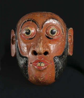 Ritual Function and Context: Kōlam theatre. UEM7030 represents a character of village headman known as Arāchchî ot Mudali. This character appears in Kōlam Theatre. This mask performs with his assistants Henchappū or Appū and brings humor to the audience through thorough their conversations. The key iconographic features of UEM7030 are: • Clear facial features: Nose, eyes and mouth • Sideburn or mustache. • Dark skin tone and two teeth coming out of ( dath-bolla ) the mouth should be personal attribute to the style of mask carver. • Influences of the iconography of figures depicted in Buddhist art in Temples. Tradition: Southern Dance Tradition/Low-Country Dance Tradition. This tradition is popular in Mātara, Bentōta, Ambalaňgoda in the Southern province and Olabodūwa in Rāiygama Kōralē in Western province of Sri Lanka. Materials and Techniques: Polychrome carved wood (white, yellow, red, black).