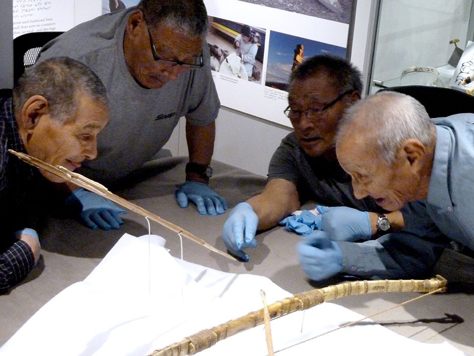 Elders Tommy Tavalok, Jimmy Qirqqut, Leo Humituq and Jonathan Hiqiniq studying arrow from Gjoa Haven/ Amundsen collection at the Nattilik Heritage Centre October 2014