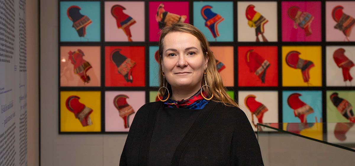 Portrait of a woman in front of several images of the traditional sámi hat for women.