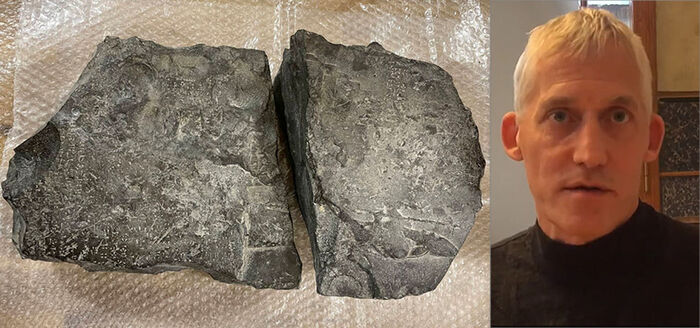 Close up of a black rock split in two parts. To the right a portrait photo of a man.