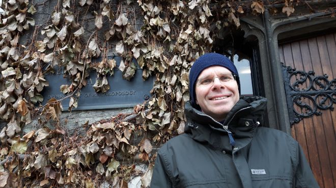 Picture of white man in front of ivy-clad building.