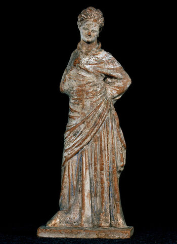(C41775) Keramikkfigur av en kvinne fra Voiotiá, Boiotia, Hellas, fra 200-tallet f.Kr. Slike figurer kalles Tanagrafigurer etter stedet hvor de fleste er funnet, og de viser nesten alltid kvinner, de fleste stående, gjerne i en dansende positur. Dette eksempelet var en gave fra arkeologen Ingvald Undset (1853–1953).