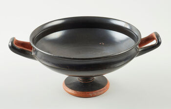 (C41782) Sortglasert drikkebeger ( kylix ) av keramikk fra Athen, 490–480 f.Kr. Den er 10,4 cm. høy. Slike begre ble brukt til å drikke vin av, som kjent på de greske symposiene. Den sorte glossen er typisk for athensk, klassisk keramikk. Eksempelet her kom til KHM i 1935, via engelske Lord Revelstokes samling.
