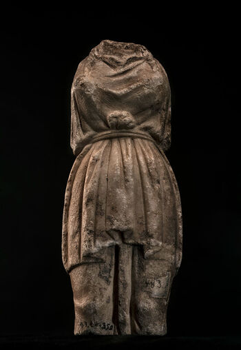 (C42027) Et 28 cm. høyt fragment av en liten statue fra det 1. århundre e.Kr. Bare kroppen er bevart, fra halsen til under knærne. Brystene viser at statuen hadde en kvinnelig form. Armene er tapt, men ser ut til å ha vært blokk-lignende, i likhet med dem man finner på hermer. Den rigide posituren og klærne ( peplos ), tilsier at statuen imiterte et xoanon , et arkaisk gudebilde. Gjenstanden, som ble innlemmet i museets samlinger på slutten av 1800-tallet, er av en ukjent proveniens.