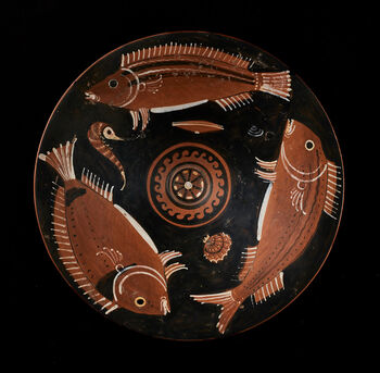 (C42180) Sortglasert keramikkfat med fisker i rødfigurstil fra Apulia i Syd-Italia. Det dateres til 340–320 f.Kr., har en diameter på 22 cm., og en fordypning for sausen i bunnen. Fiskene er av arten brasme, som var vanlig i middelhavslandenes kosthold. Tilsvarende fat har blitt funnet med rester av fiskeben i et gravkammer i Palermo. Eksempelet her kom til KHM i 1935, via engelske Lord Revelstokes samling.