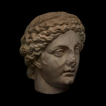 (C42183) Et 24,5 cm. høyt hode av marmor med skinnende krystaller viser sannsynligvis en muse eller en nymfe fra den gresk-romerske mytiske sfæren. Det dateres stilistisk til 160–180 e.Kr., og er sannsynligvis fra en statue fra det østlige middelhavsområdet. Det er brutt av ved halsen, og overflaten har noen skader. Hodet tilkom museet som en gjenstand i Baron Platon von Ustinows (1840–1917) samling.