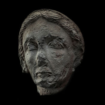 (C42240) Hodet av kalksten på 25 cm., brutt av fra en gravbyste for en godt voksen kvinne som levde i Skythopolis (Beit She’an), Israel, mellom 200 og 250 e.Kr. Det er laget av kalksten, og selv om det er skadet, kan man se at det skiller seg fra hoder på tilsvarende gravbyster fra det samme stedet. Det innebærer at det sannsynligvis var en kunstner som kom fra et annet sted, som laget det. Flere billedhuggere var omreisende, og den som laget dette kan ha hentet impulser fra andre deler av Romerriket, som for eksempel Syria. Kvinnehodet tilkom museet som en gjenstand i Baron Platon von Ustinows (1840–1917) samling.