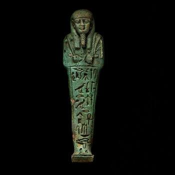 (C47015) Gravfigur av grønn fajanse med en høyde på 14,3 cm. fra 525–404 f.Kr. Slike mumieliknende figurer kalles usjebtier , og er bevart i mengder, ettersom de ble plassert i graver, for å tjene de døde i etterlivet. De er dekorert med hieroglyfer som oppgir navnet til sin herre, som i dette tilfellet var Ankhhep, «byens borgermester». I hendene har figuren en øks, en hakke og et nett. Eksempelet her ble anskaffet i Egypt via Jens Lieblein (1827–1911), Norges første egyptolog, sannsynligvis mellom 1967 og 1870.