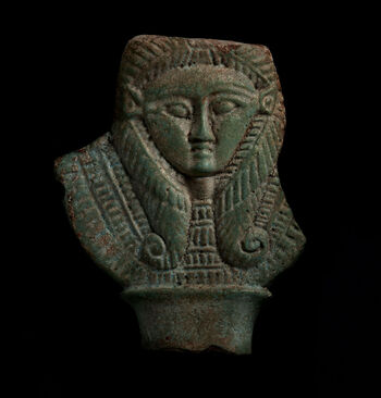 (C47573) Fragment av et sistrum (egyptisk instrument, en slags rangle) av fajanse dekorert med et gudinnehode. Det er 9 cm. høyt, og dateres til 664–33 f.Kr. På den tiden symboliserte kuørene og parykken med de tunge hårlokkene gudinnen Hathor, beskytteren av kvinnelig kjærlighet, morskjærlighet og glede. Fragmentet ble anskaffet i Egypt mellom 1967 og 1870 via Jens Lieblein (1827–1911), Norges første egyptolog.