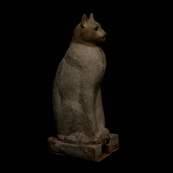 (C47689) Mumiekiste av tre for en mumifisert katt, fra 332–395 e.Kr. fra Egypt. Den er 64 cm. høy og består av to vertikale deler; kattemumien har gått tapt. Opprinnelig var kroppen malt hvit, og hodet var sannsynligvis dekket av messingfolie, som har etterlatt en grønnlig korrosjon. Katten representerte gudinnen Bastet, beskytteren av familieliv og glede, og det viktigste kultsenteret for henne var i Bubastis (Tell Basta), hvor det var en stor gravplass for katter. Denne kisten kan komme derfra. Den ble anskaffet i Egypt mellom 1967 og 1870 via Jens Lieblein (1827–1911), Norges første egyptolog.