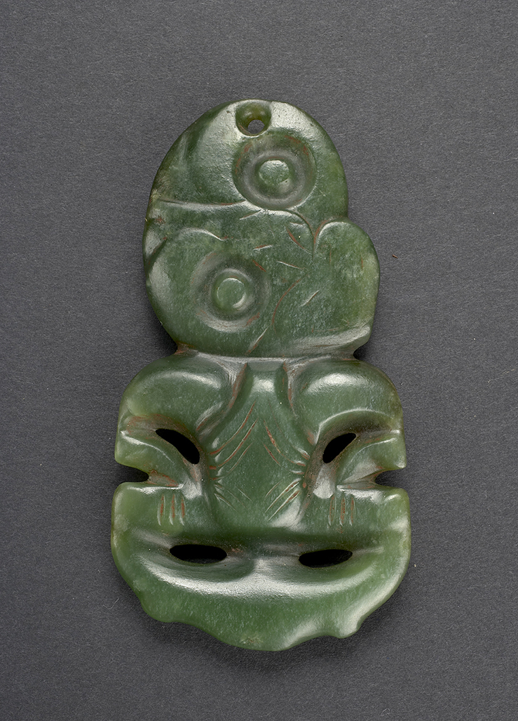 (UEM144a)&amp;#160;Anheng eller hei tiki. 9,4 cm. Hei tiki er en svært stilisert fremstilling av menneskeformen. Vanligvis betraktet som enten kvinnelig eller kjønnsløs. De skrevende hoftene, vulvaen som noen ganger er utvidet, svulmende øyne og hendene i siden anses å være fremstillinger av en kvinne i fødsel, og dermed kan gjenstandene også assosieres med fruktbarhetsguder. Disse antropomorfe anhengene er laget av jade (nefritt), og regnes blant de mest verdifulle&amp;#160;taongaene&amp;#160;(skatter) blant maoriene. Jade er vanlig forekommende på Sørøya på Aotearoa New Zealand, men hei tiki blir vanligvis forbundet med Nordøya. Siden hei tiki er verdifull blir gjenstanden vanligvis forbundet med overklassen blant maoriene, noe som gir gjenstanden mana (makt). Selv om den ikke er nøyaktig datert, kan hei tiki spores tilbake til den klassiske maoriperioden (Te Puawiatanga, 1500–1800).&amp;#160;&amp;#160;&amp;#160; Gjenstanden ble innsamlet av Fredrik Ring i Valparaiso i Chile på 1820-tallet. Konsul Ring donerte gjenstanden til Etnografisk museum i 1833.&amp;#160;&amp;#160; Materiale: Jade/halvedelsten Region og kultur: Hokianga, New Zealand – Maori