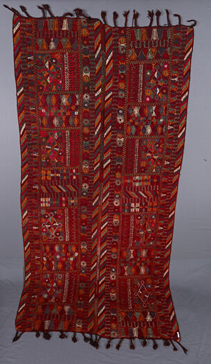 UEM49195. Triple border. De loddrette kantene til teppets to paneler består av karakteristiske flerfargede diagonale linjer. Hvert panel er delt inn i fire seksjoner med et sentrert diamantmotiv. Rundt dette motivet er det geometriske mønstre, blomster og andre vegetabilske motiver. Det er også en rytter på ett av panelene. Broderiet er tynt gjennomarbeidet og dekker ikke hele tekstilen på undersiden. Man kan anta at bakgrunnsfargen er anvendt som en del av det dekorative opplegget. Frynsene er flettet.