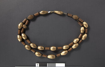 (UEM46960) Halskjede av gullbelagt håndskårne treperler, skinn og gullimitasjon (Ser-alek . Ser  betyr gull.) Laget av Sar`et Rongpi, Lindok of Rong`arak. Karbi Anglong, Hamren og Ronghang Rongbong.