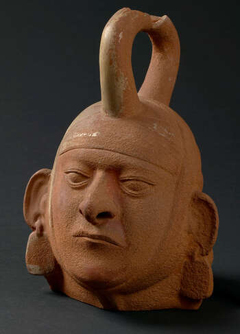 (UEM9971) Flaske med stigbøylehals i form av portrett av dignitær med hodetørkle og ørepynt. Laget ved hjelp av prefabrikkert form. Halsen mangler. Moche, 100 – 800, Peru.