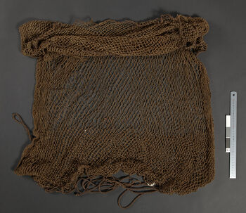 (UEM12197)&amp;#160;Misjonær Bodding skrev: 'Jegeren sprer nettet på bakken og dekker det med blader. Åte strøs over, og når fuglene har samlet seg trekkes det til slik at nettet samler seg i toppen.Dette nettet anvendes gjerne i de varme årstiden når fuglene kommer for å drikke vann. Nettet spres da gjerne ut i grunt vann.' Materiale: Vegetabilsk fiber. Lengde: 163 cm, vidde: 117 cm.
